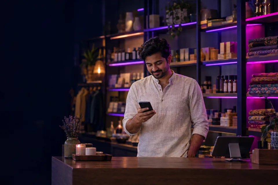 Indian shop owner checking his phone in a modern boutique